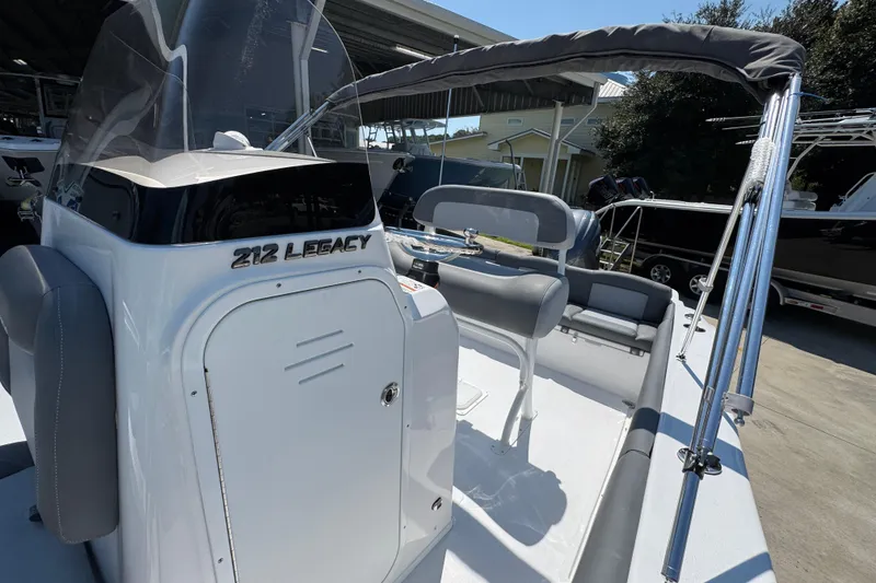 Slide: The Image of 2026 NauticStar 212 Legacy boat interior with seating and console, docked outdoors. - 22