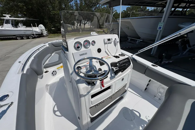 Slide: The Image of 2026 NauticStar 212 Legacy boat interior with steering console and seating area. - 28