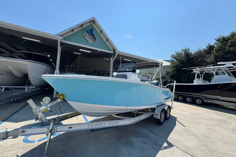 Slide: The Image of 2026 NauticStar 212 Legacy boat on trailer at marina under clear sky. - 3