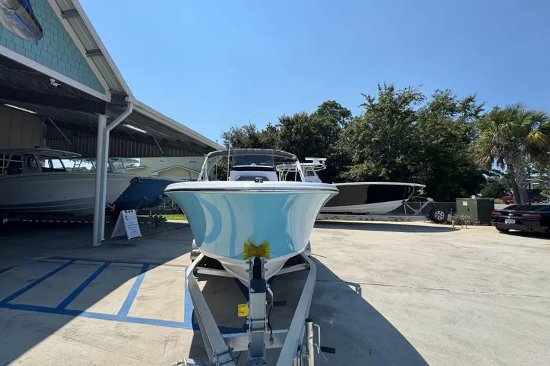 Slide: The Image of 2026 NauticStar 212 Legacy boat on trailer in sunny outdoor showroom. - 5