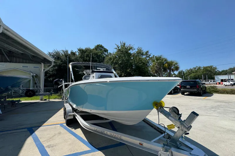 Slide: The Image of 2026 NauticStar 212 Legacy boat on trailer, parked outdoors under clear blue sky. - 6