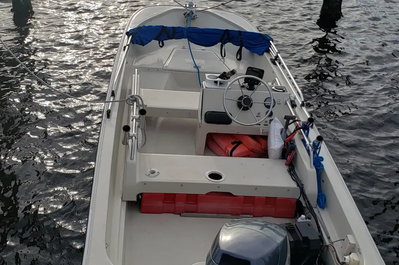 Slide: The Image of 1991 Boston Whaler 15 GLS boat on water, featuring steering wheel and seating area. - 5