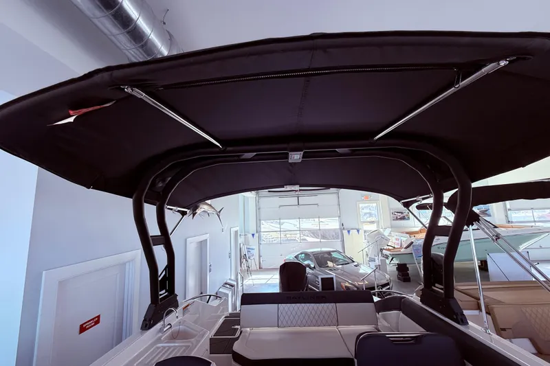 Slide: The Image of 2026 Bayliner D22 boat interior with black canopy in showroom setting. - 14