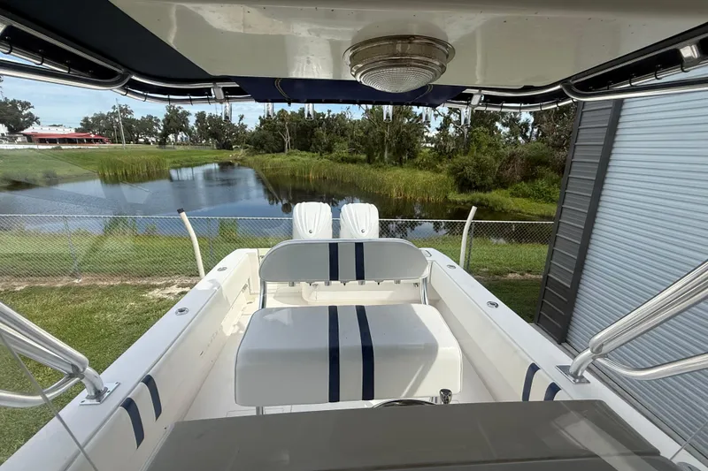 Slide: The Image of 2008 Contender 31 Cuddy boat interior with seating, near a serene pond. - 10