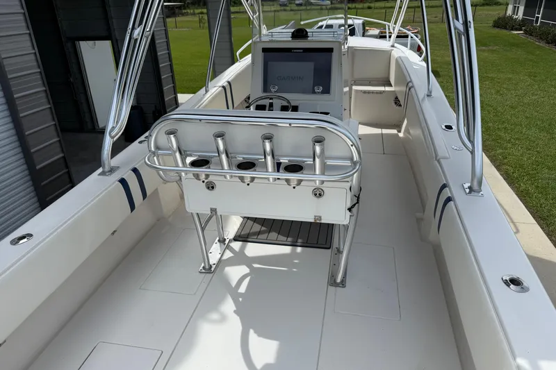Slide: The Image of 2008 Contender 31 Cuddy boat interior with steering console and rod holders. - 12