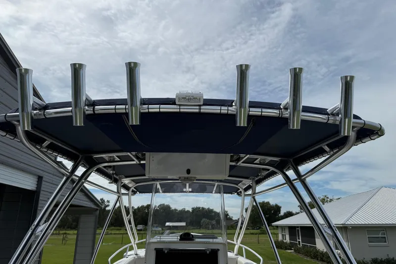 Slide: The Image of 2008 Contender 31 Cuddy boat with T-top and rod holders under a cloudy sky. - 26