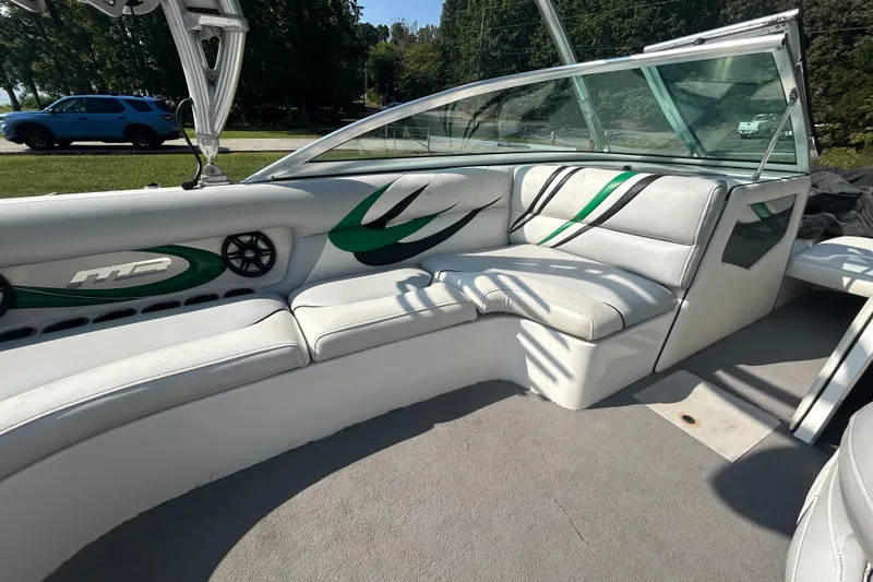 Slide: The Image of 2011 MB F21 Tomcat boat interior with white and green seating, outdoor setting. - 4