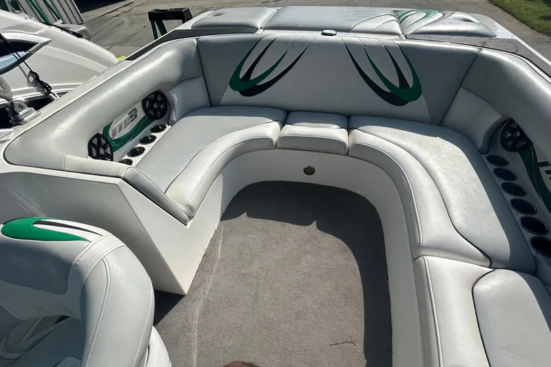Slide: The Image of 2011 MB F21 Tomcat boat interior with white and green seating, cup holders, and speakers. - 5