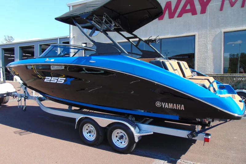 Slide: The Image of 2026 Yamaha Boats 255XD in blue and black on a trailer outside a dealership. - 3