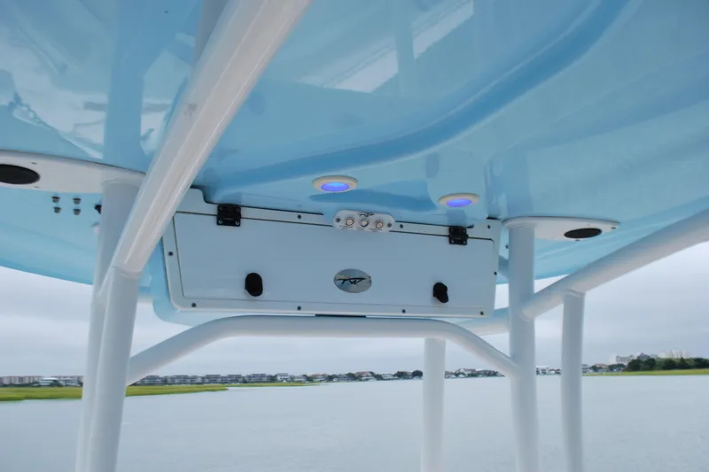 Slide: The Image of Tidewater 220 LXF 2020 boat T-top with blue underside and storage compartment. - 11