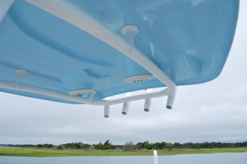 Slide: The Image of 2020 Tidewater 220 LXF boat with blue T-top and rod holders, scenic water view. - 12