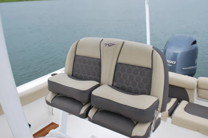 Slide: The Image of 2020 Tidewater 220 LXF boat seats with hexagonal pattern, near water. - 14