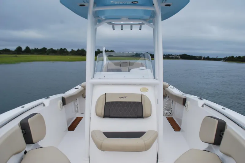 Slide: The Image of 2020 Tidewater 220 LXF boat interior with cushioned seating on a calm waterway. - 7