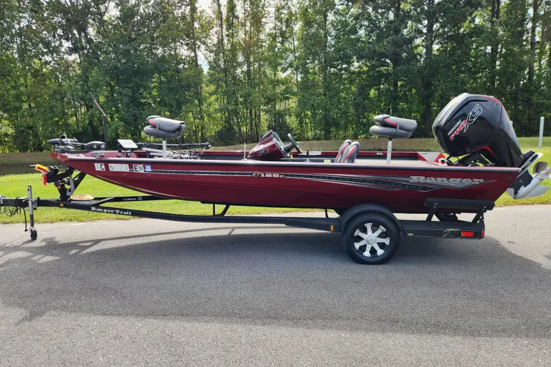 Slide: The Image of 2019 Ranger RT188C boat on trailer, parked on road with forest background. - 0