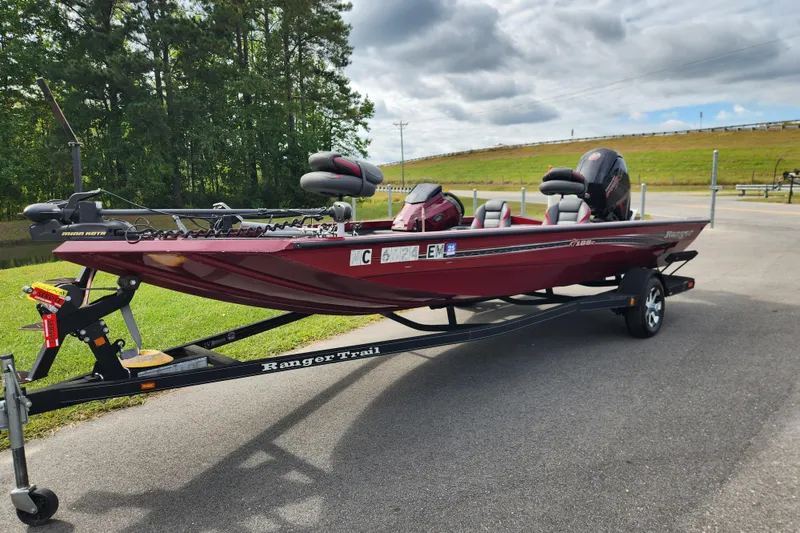 Slide: The Image of 2019 Ranger RT188C boat on trailer, parked outdoors with trees and cloudy sky. - 1