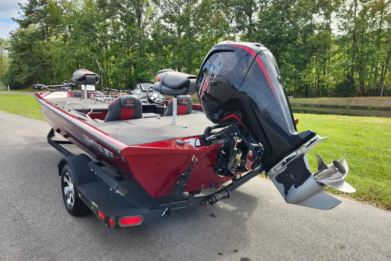 Slide: The Image of 2019 Ranger RT188C boat with powerful outboard motor on a trailer, parked near lush greenery. - 3