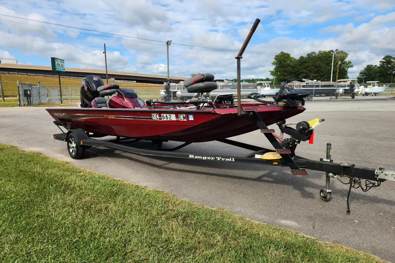 Slide: The Image of 2019 Ranger RT188C boat on trailer, parked outdoors under a cloudy sky. - 7