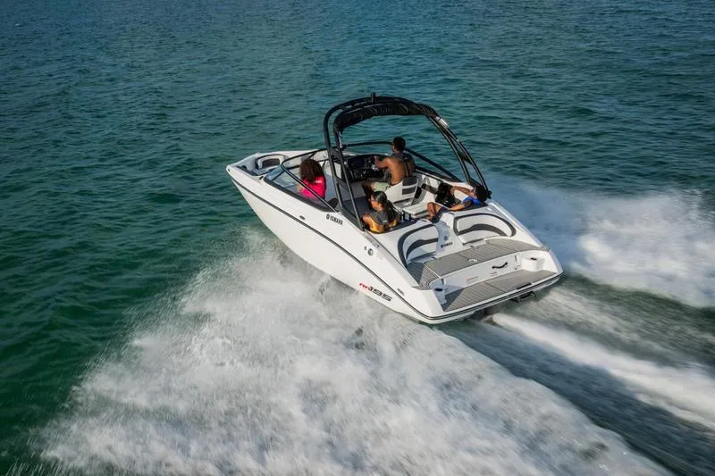 Slide: The Image of 2025 Yamaha Boats AR195 speeding on open water with passengers enjoying the ride. - 9