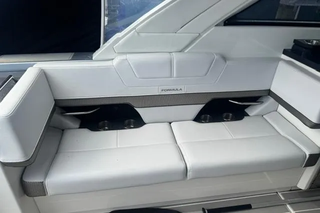 Slide: The Image of 2020 Formula 380 Super Sport Crossover I/O boat interior with white seating and cup holders. - 27