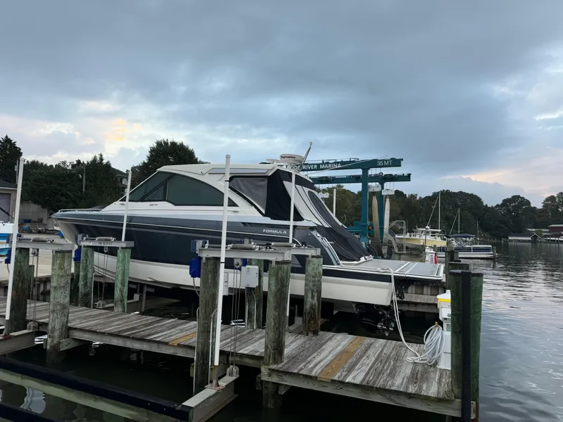 Slide: The Image of 2020 Formula 380 Super Sport Crossover I/O docked at a marina under cloudy skies. - 4