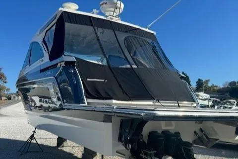 Slide: The Image of 2020 Formula 380 Super Sport Crossover I/O boat, docked, with black canopy. - 7