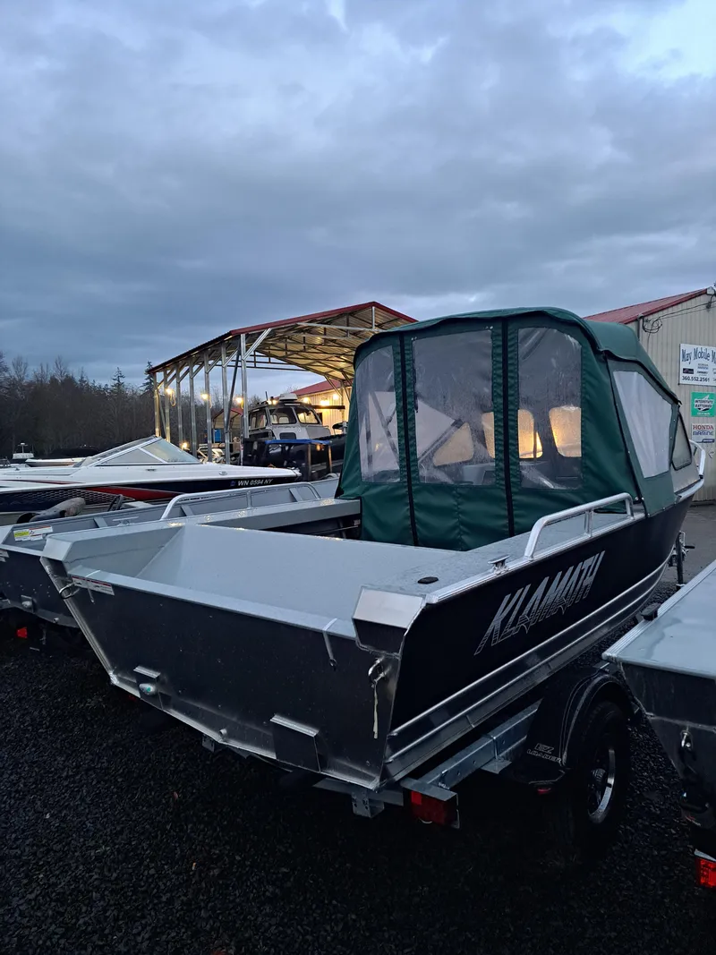 The Image of 2025 Klamath 19 GTX boat with green canopy in a marina setting. - 0