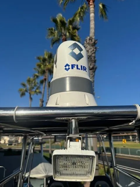 Slide: The Image of 2022 Allmand 31 RIB with FLIR camera and light, palm trees in background. - 2