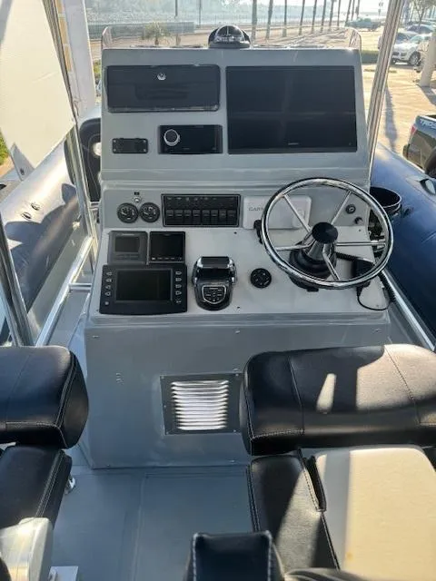 Slide: The Image of 2022 Allmand 31 RIB boat dashboard with steering wheel and navigation controls. - 6