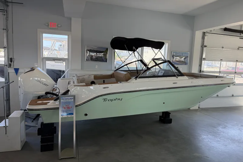 Slide: The Image of 2025 Bayliner Trophy T22SC boat displayed in showroom with Mercury engine. - 0