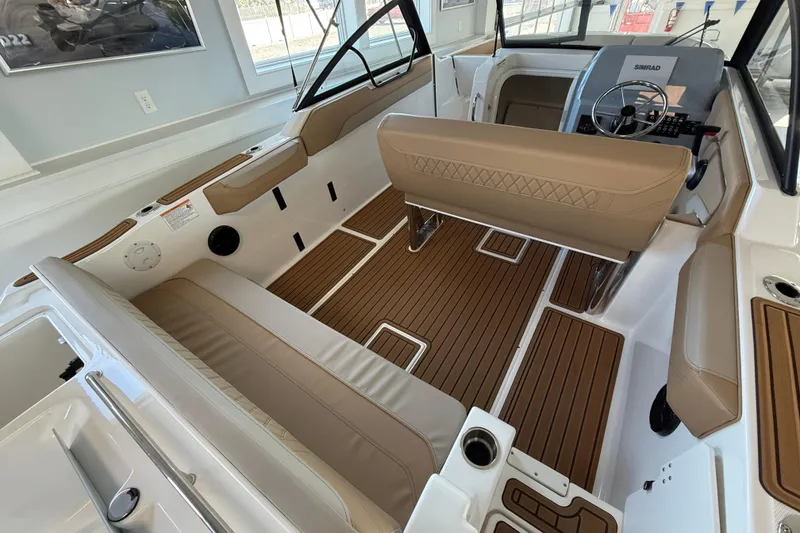 Slide: The Image of 2025 Bayliner Trophy T22SC boat interior with tan seating and wood-style flooring. - 10