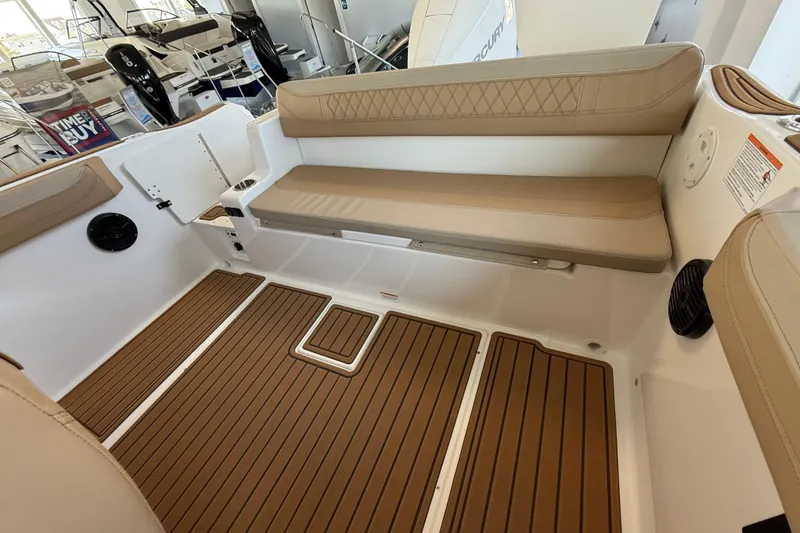 Slide: The Image of 2025 Bayliner Trophy T22SC boat interior with tan seating and wood-style flooring. - 11