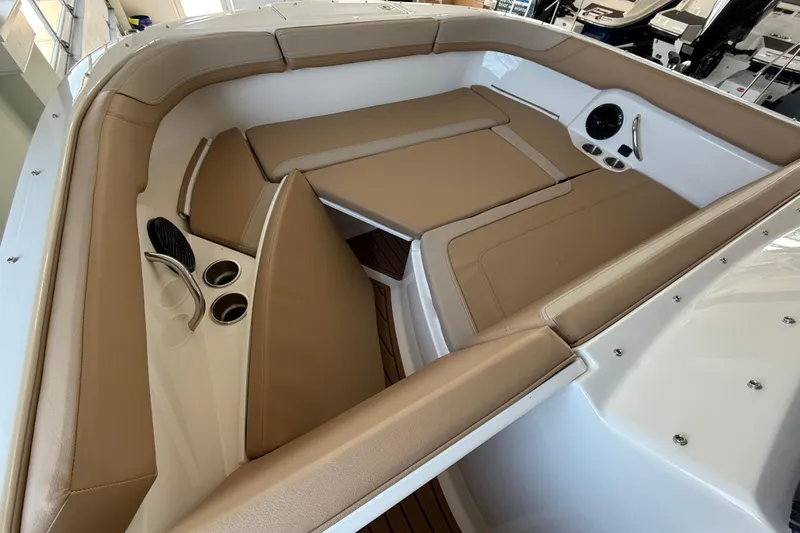 Slide: The Image of 2025 Bayliner Trophy T22SC boat interior with tan seating and cup holders. - 13