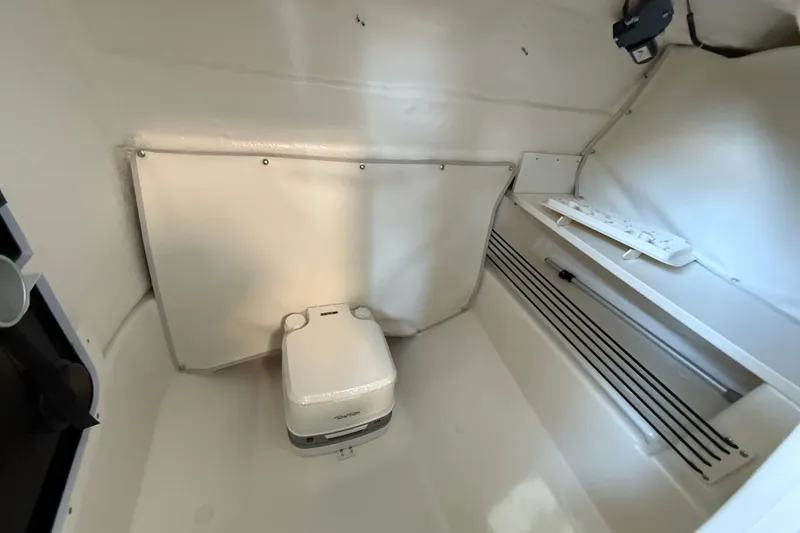 Slide: The Image of 2025 Bayliner Trophy T22SC interior with compact portable toilet and storage space. - 15