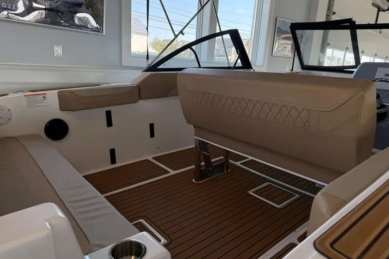 Slide: The Image of Interior of 2025 Bayliner Trophy T22SC boat with tan seating and wood flooring. - 7