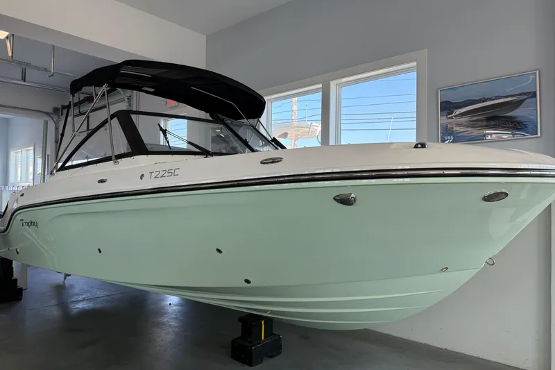 Slide: The Image of 2025 Bayliner Trophy T22SC boat displayed indoors, featuring sleek design and mint green hull. - 9