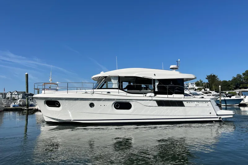 The Image of 2026 Beneteau 41 Swift Trawler Sedan on calm water, showcasing sleek design. - 0