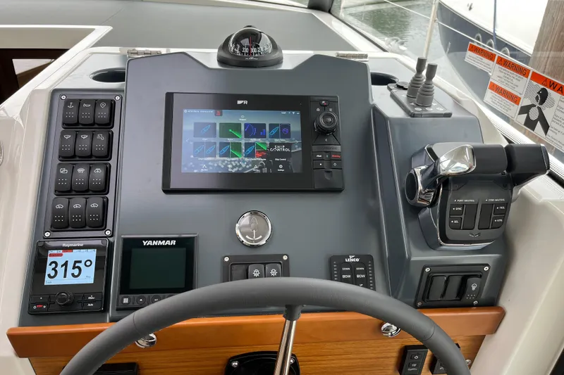 Slide: The Image of 2026 Beneteau 41 Swift Trawler Sedan helm with advanced navigation controls and digital displays. - 13