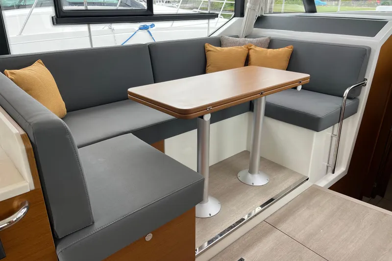 Slide: The Image of Interior seating area of 2026 Beneteau 41 Swift Trawler Sedan with table and cushions. - 16