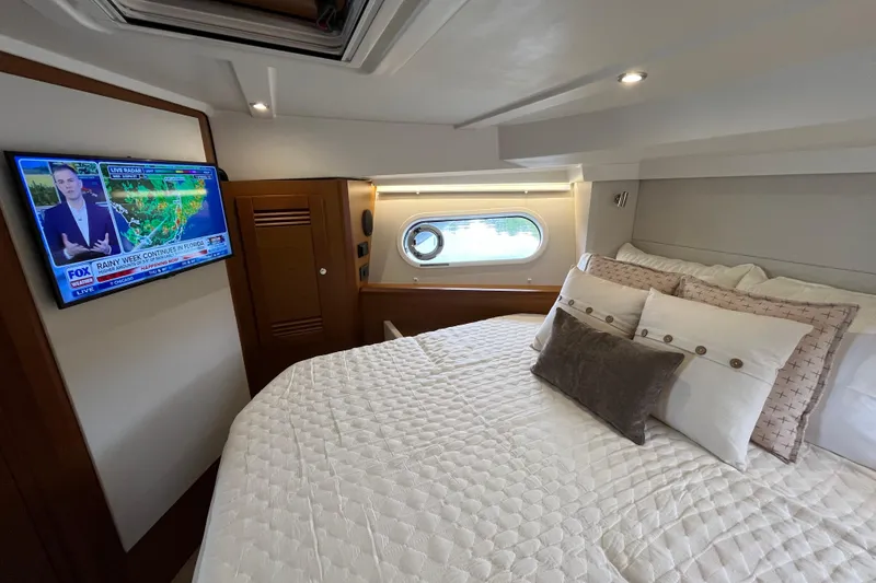 Slide: The Image of Luxurious bedroom in 2026 Beneteau 41 Swift Trawler Sedan with TV and porthole view. - 27