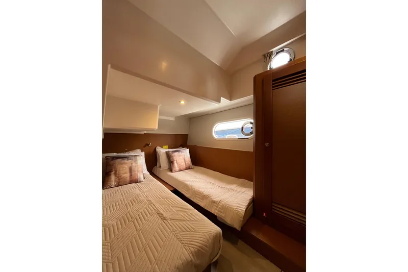 Slide: The Image of Interior of 2026 Beneteau 41 Swift Trawler Sedan with twin beds and porthole. - 30
