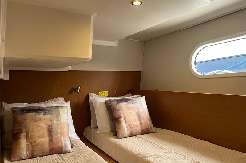 Slide: The Image of 2026 Beneteau 41 Swift Trawler Sedan cabin with twin beds and modern decor. - 31