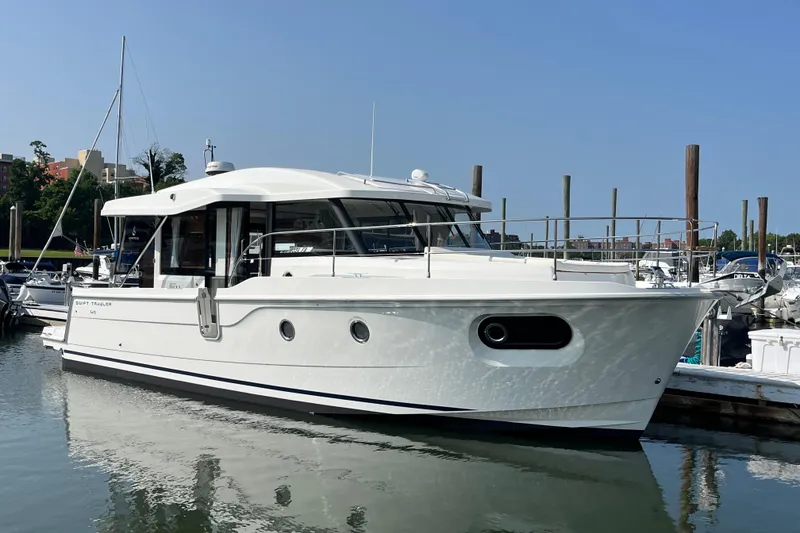 Slide: The Image of 2026 Beneteau 41 Swift Trawler Sedan docked at marina under clear blue sky. - 4
