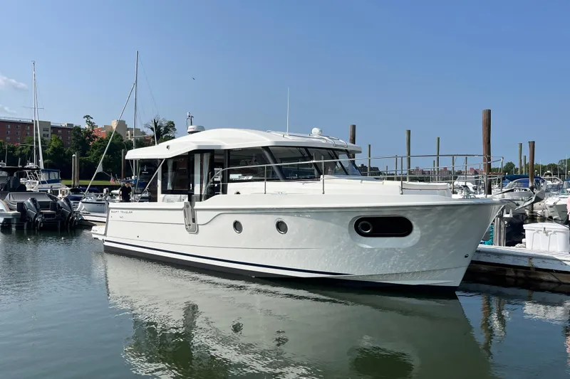 Slide: The Image of 2026 Beneteau 41 Swift Trawler Sedan docked in a marina under clear skies. - 5