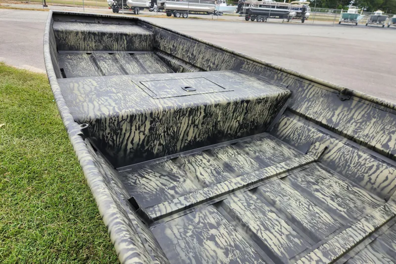Slide: The Image of 2026 Tracker Grizzly 15 Jon boat with camouflage interior, parked on grass. - 9