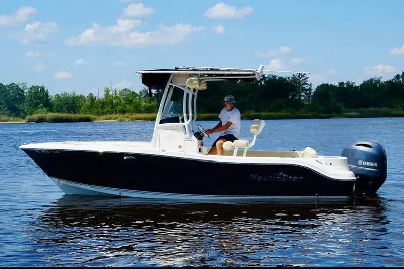 The Image of 2018 NauticStar 2102 Legacy boat on calm water with a Yamaha engine. - 0