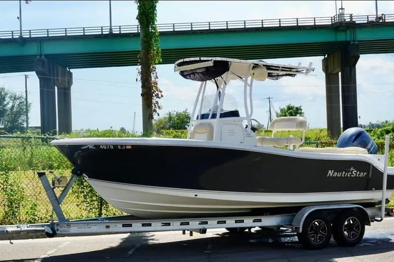 Slide: The Image of 2018 NauticStar 2102 Legacy boat on trailer under bridge. - 4