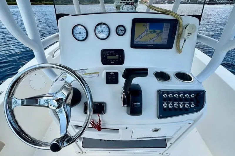 Slide: The Image of 2018 NauticStar 2102 Legacy boat dashboard with steering wheel, gauges, and navigation system. - 5