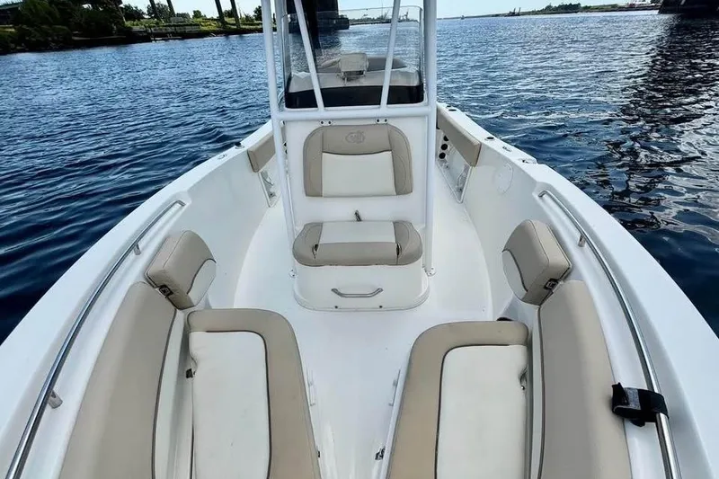 Slide: The Image of 2018 NauticStar 2102 Legacy boat interior with cushioned seating on calm water. - 8