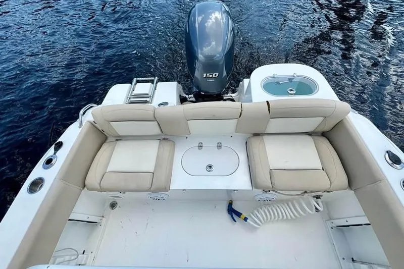 Slide: The Image of 2018 NauticStar 2102 Legacy boat interior with seating and outboard motor on water. - 9