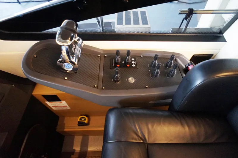 Slide: The Image of Control panel of a 2016 Pershing 70 yacht with joystick controls and leather seating. - 1